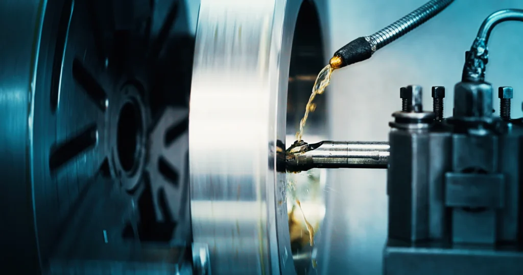 Oil streaming from a nozzle onto a rotating machine part